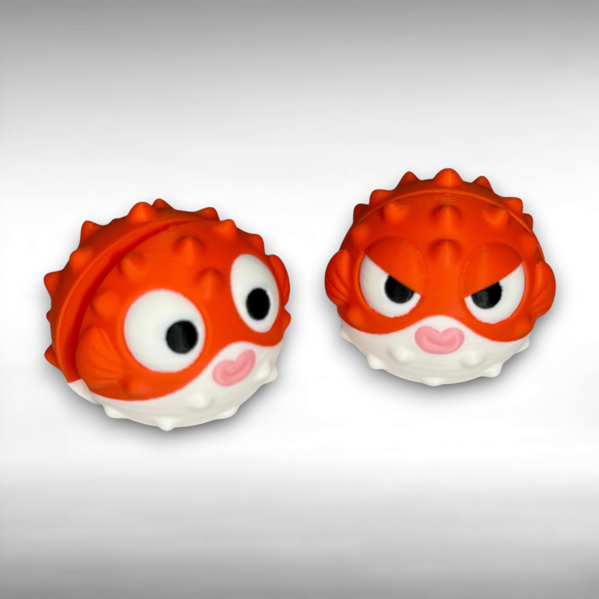 Two orange and white puffer fish figures, one with a circular eyes and one with slanted eyes, on a gray background