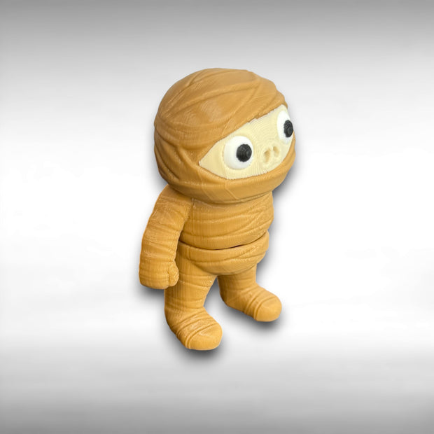 3D-printed mummy toy on a gray background