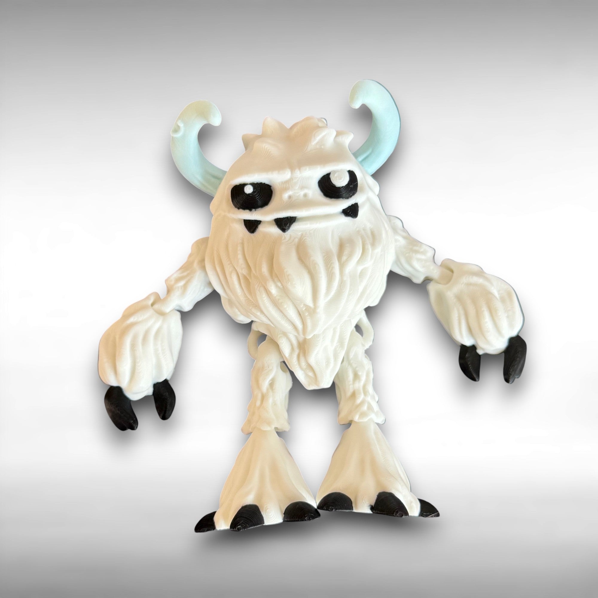 3d-printed toy figure of a creature with white hairy body, black eyes, and blue horns on a gray background