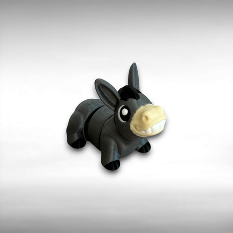 Black and beige donkey-shaped toy on a gray background