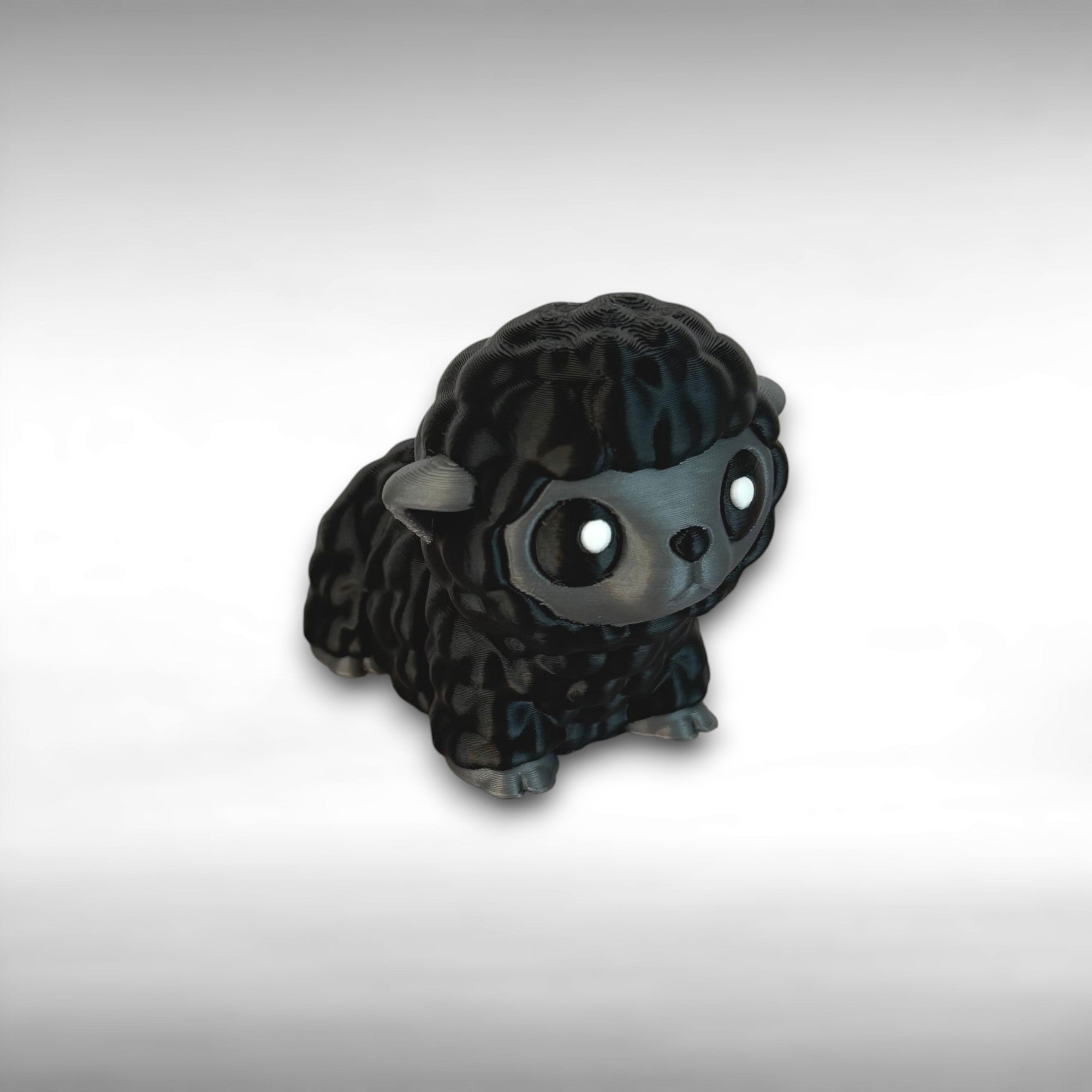 3D-printed articulated black and gray sheep figurine on a light background