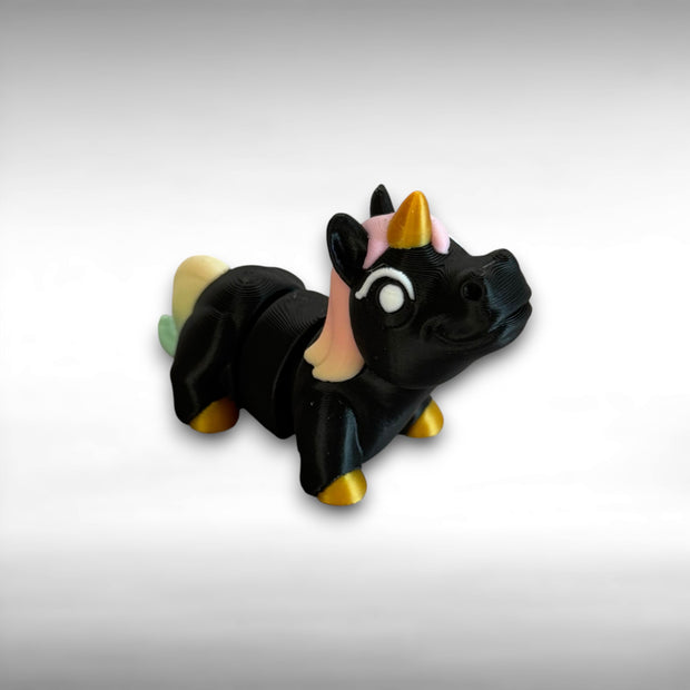 A small 3D printed articulated mini unicorn toy with articulated segments, black body, rainbow hair, and golden hooves and horn on a white background.