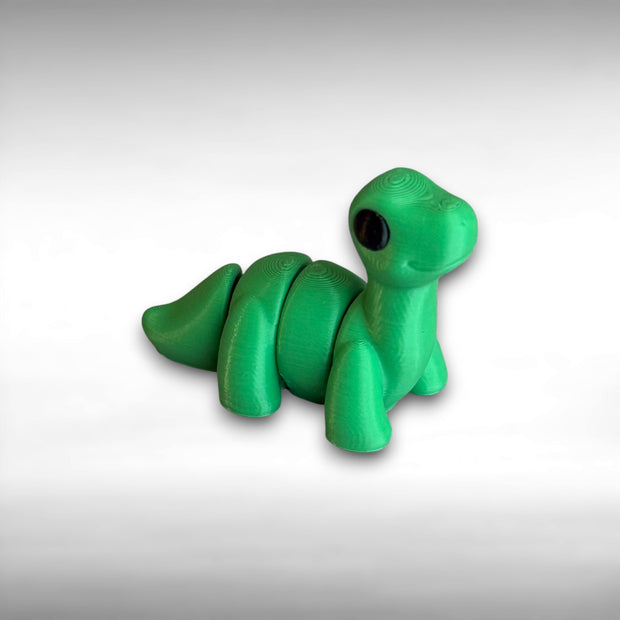 A small 3D printed articulated green brontosaurus toy with articulated segments on a white background