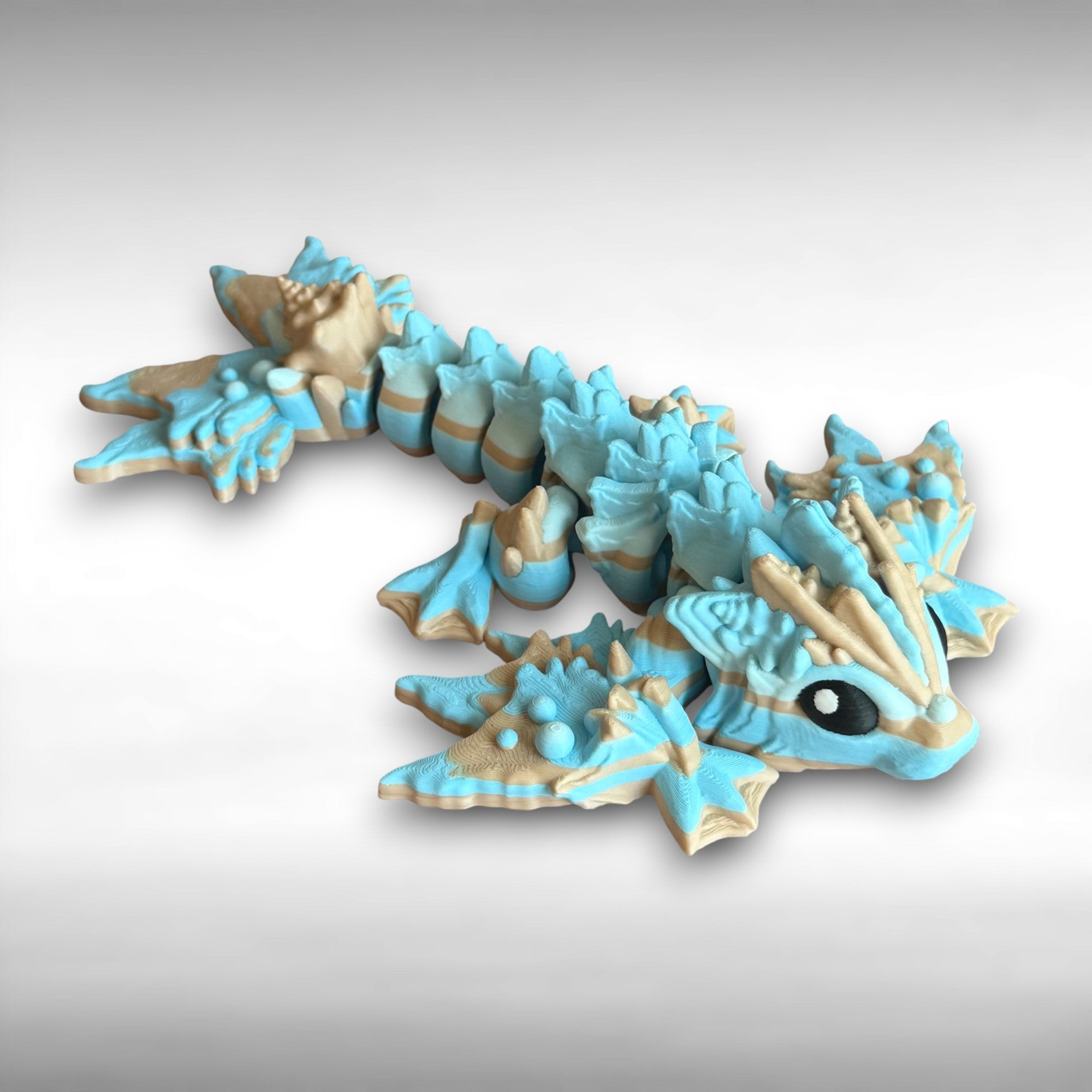 Toy dragon figurine with blue and beige colors on a gray background