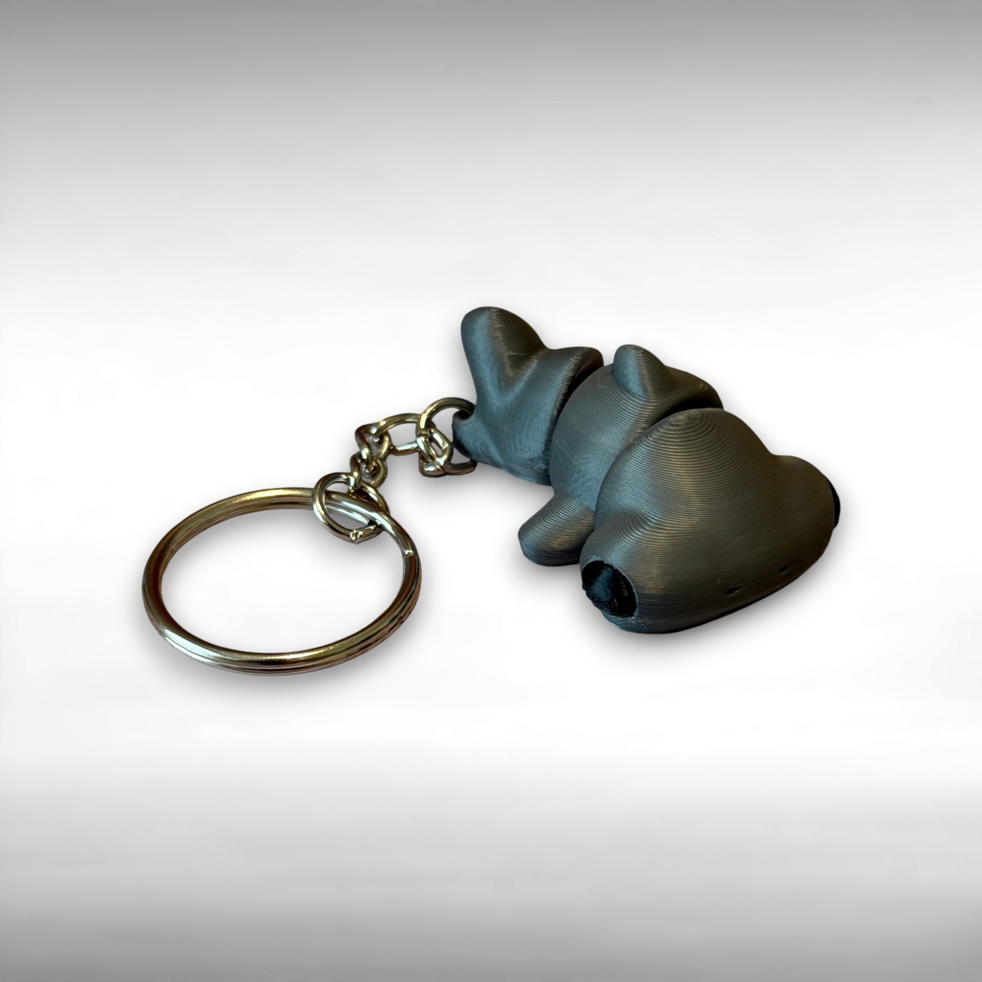 Keychain of 3d printed gray articulated hammer head shark against a white background