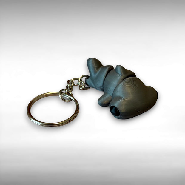 Keychain of 3d printed gray articulated hammer head shark against a white background