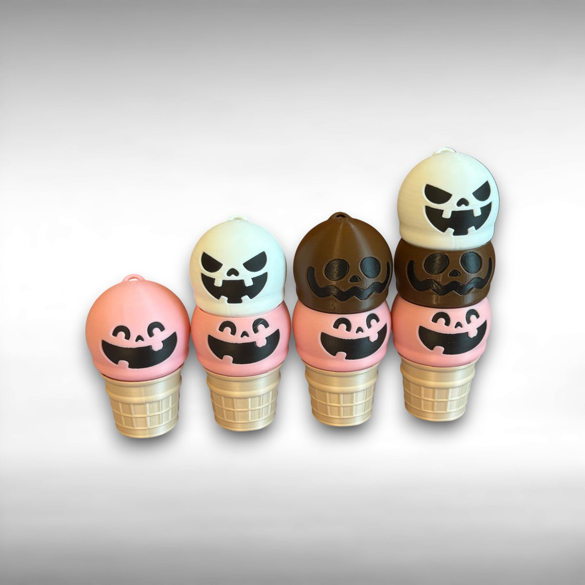 Set of Halloween-themed ice cream cone-shaped keychains with jack-o'-lantern faces on a light gray background.