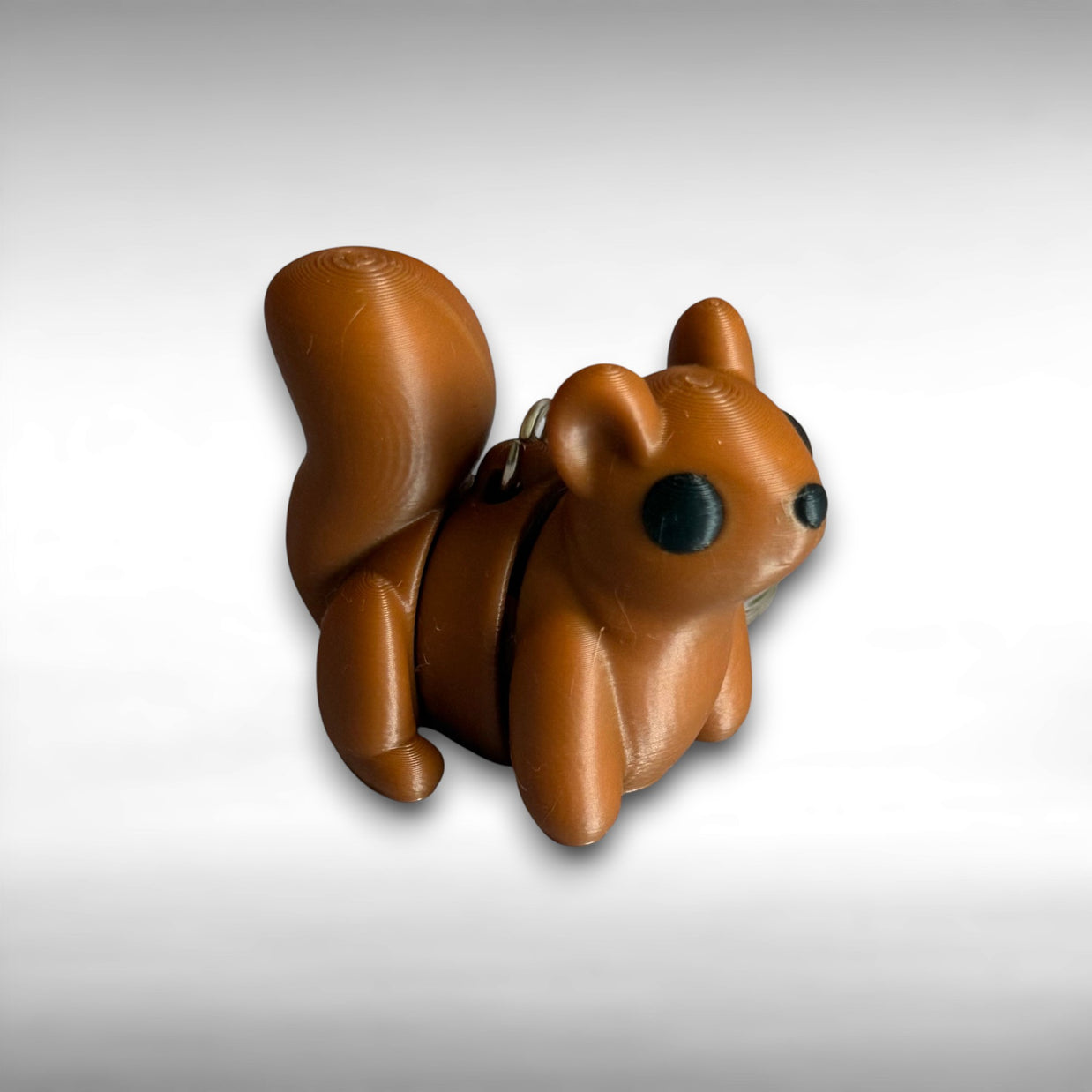3D printed brown squirrel-shaped keychain on a light gray background