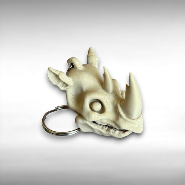 3D printed beige rhino skull keychain against a white background