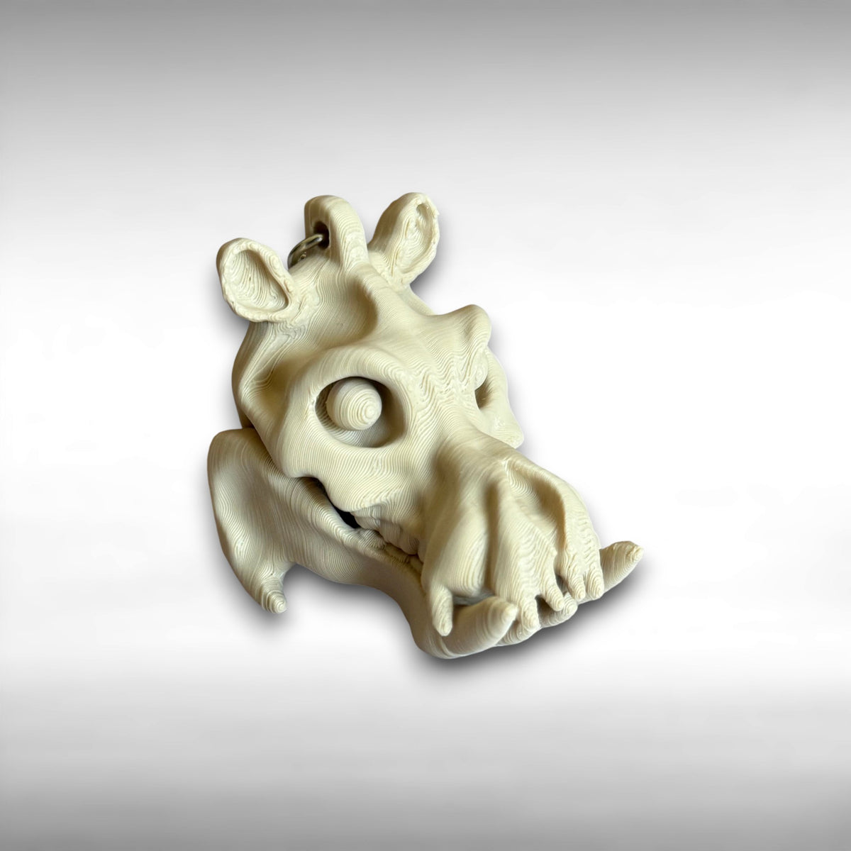 3D printed beige hippo skull keychain against a white background