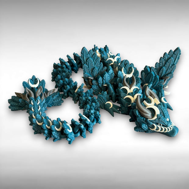 A 3D printed, blue articulated dragon toy with white celestial-inspired patterns on a white background
