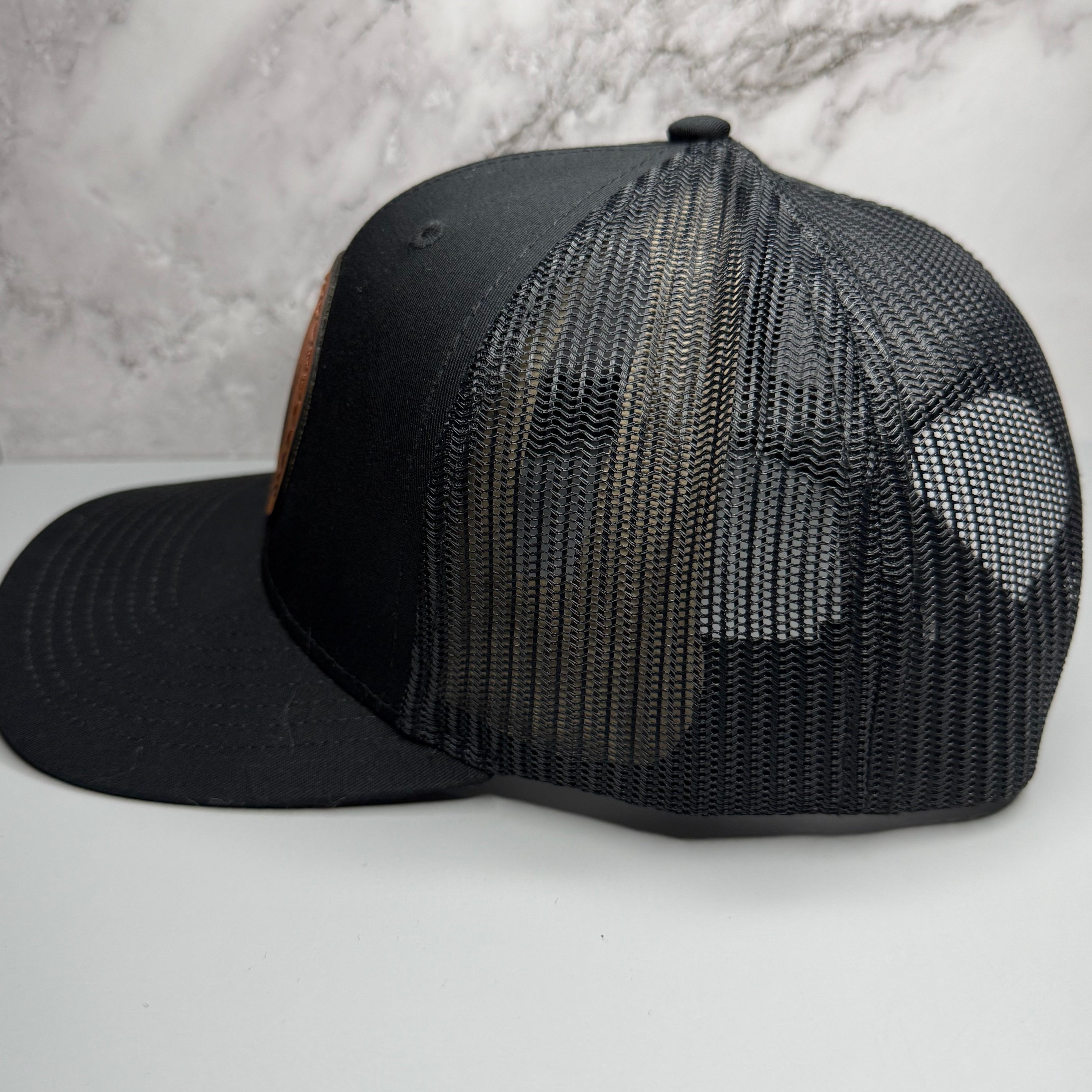 Black mesh trucker cap on a light gray background