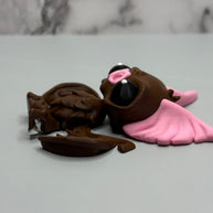 Right side of a figure of a brown bat with pink ears and nose on a gray background