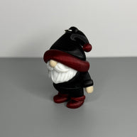 Gnome-shaped keychain in black with a red shimmer and black hat, white beard, and red shimmer shoes. 