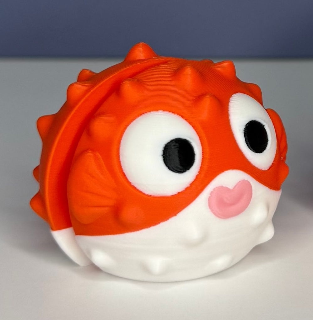 Orange and white puffer fish figure with a circular eyes on a blue and white background