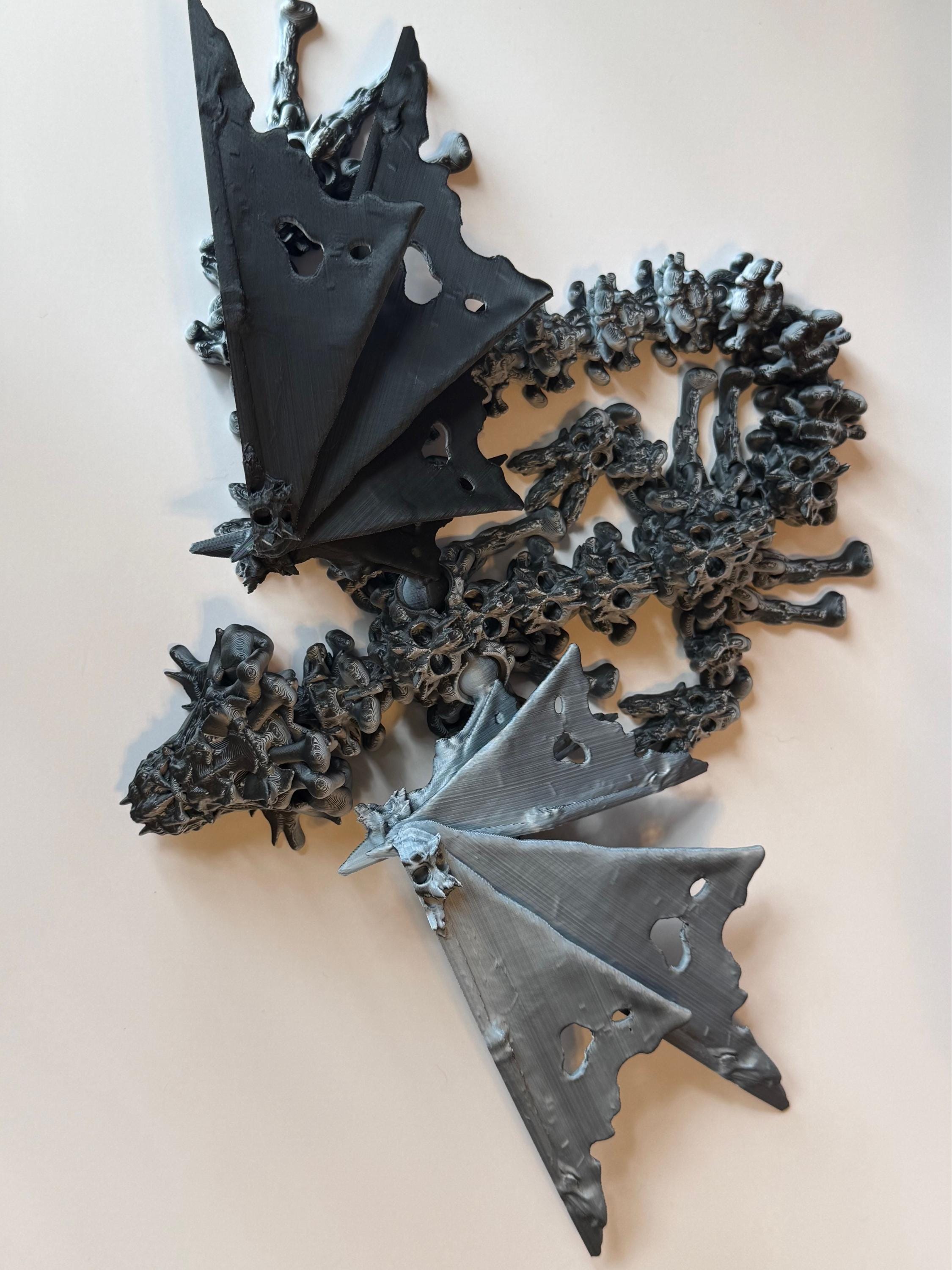 Winged black and white 3d printed dragon with a hollow theme consisting of skulls and bone-like features against a white background