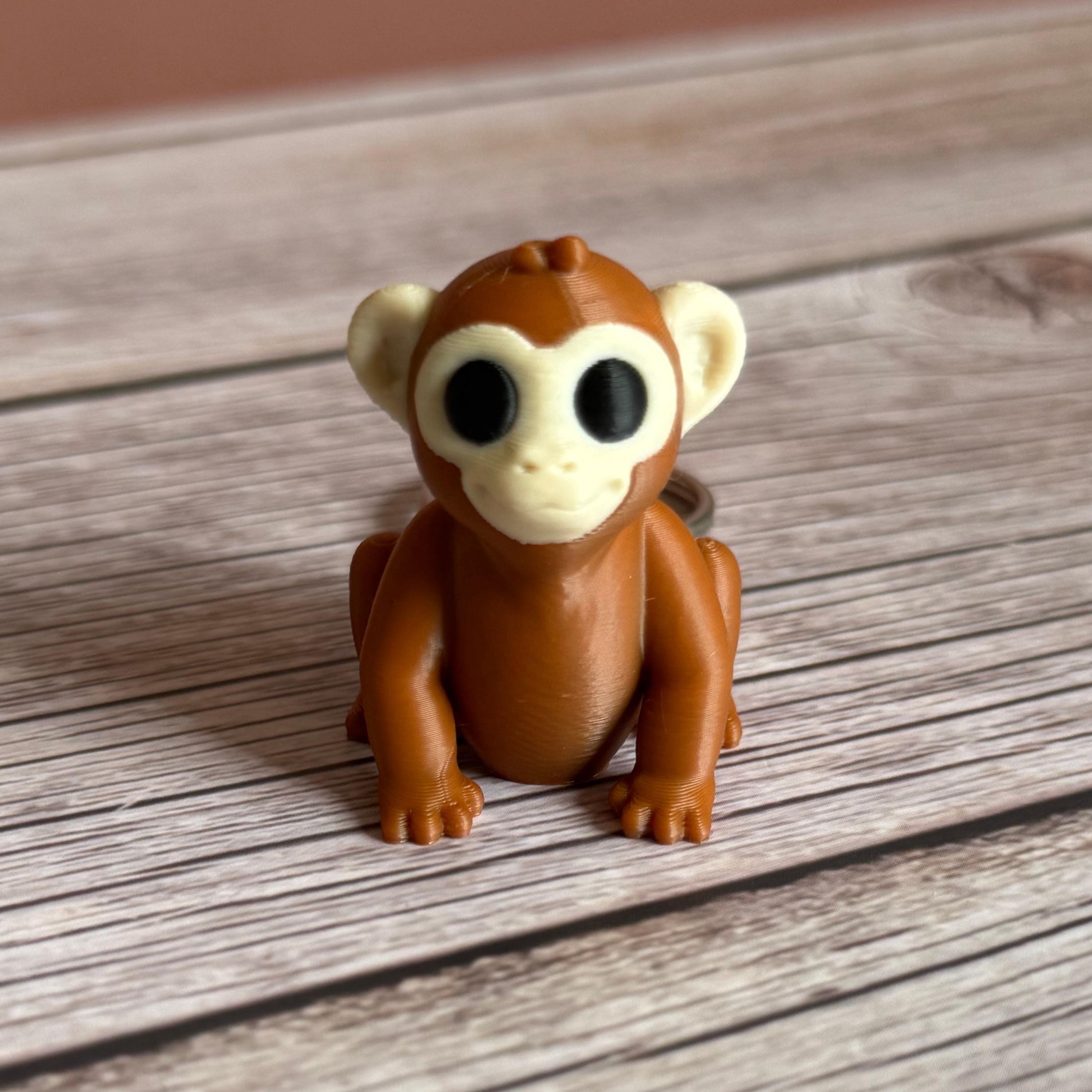 3D printed brown monkey-shaped keychain on a wooden surface