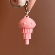 A 3D printed pink articulated jellyfish keychain attached to a keyring, displayed against a brown background.