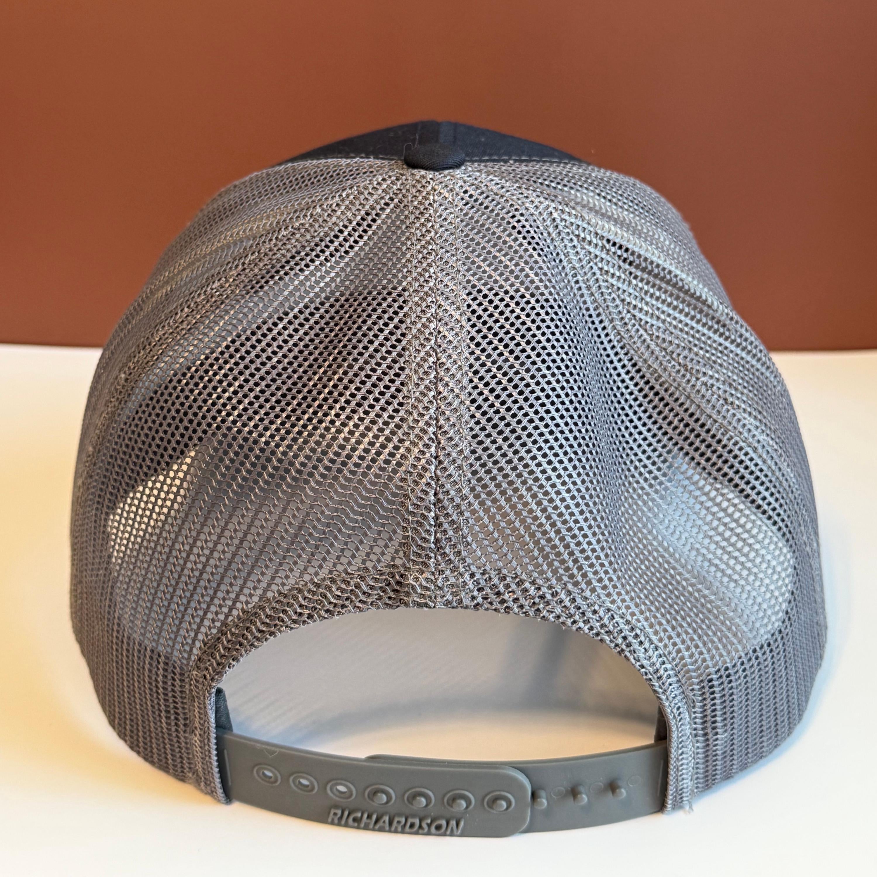 Gray backside of snapback hat against a white and brown background