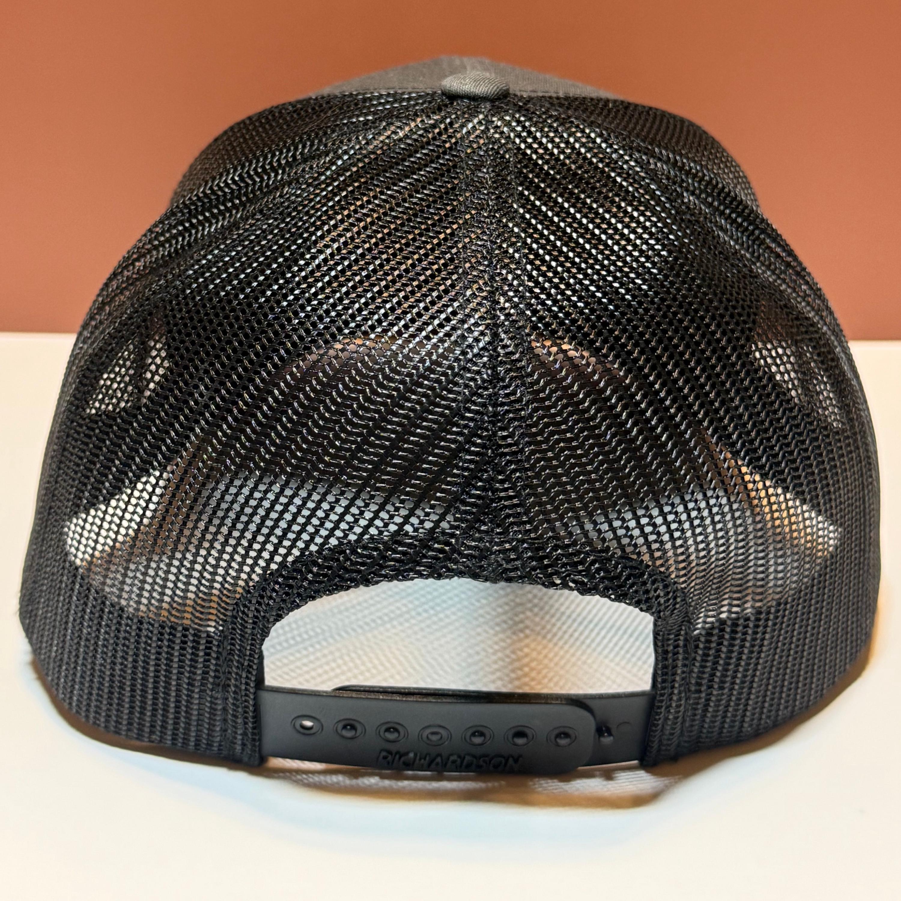 Black mesh backside of a Richardson hat on a white and brown background