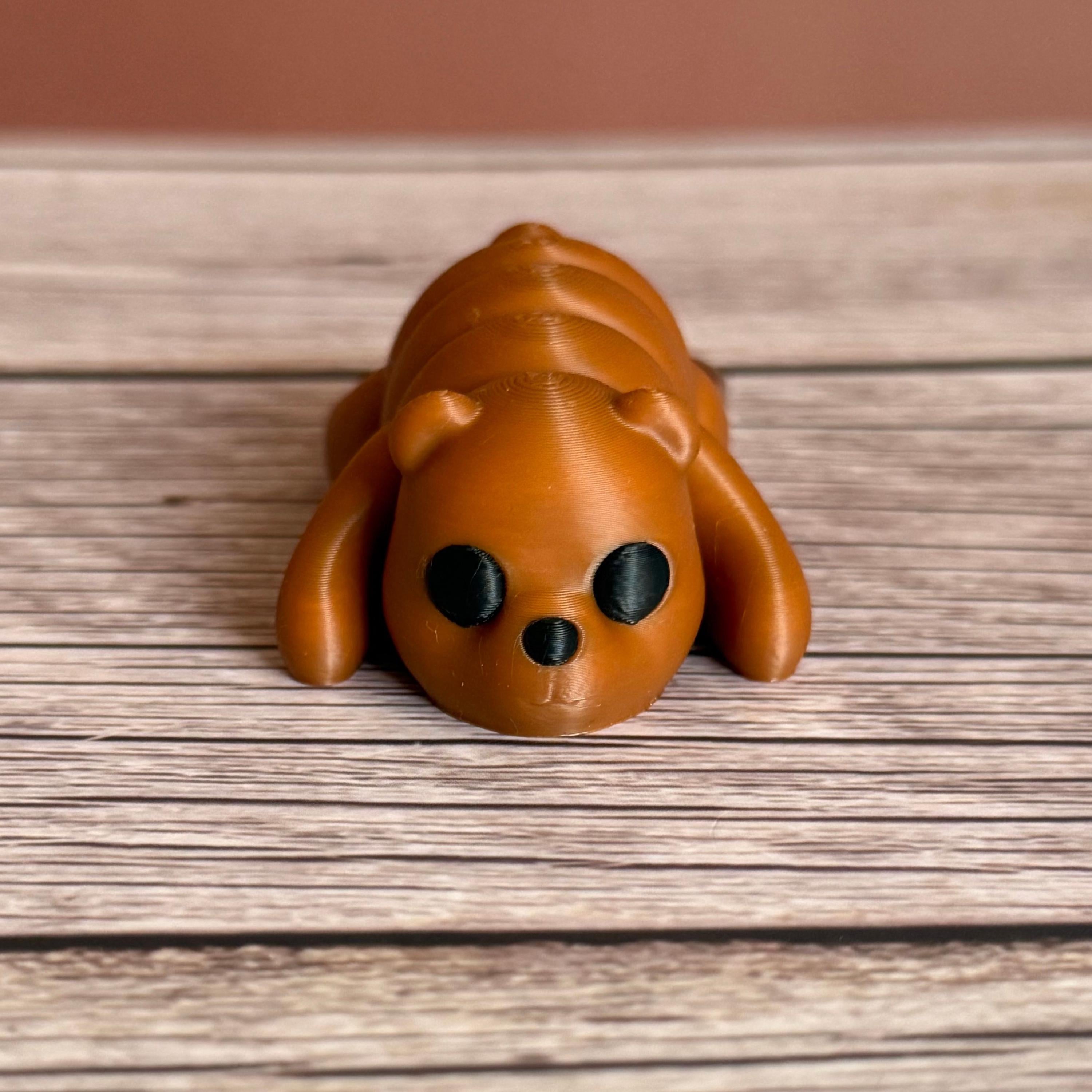 3D printed brown bear-shaped keychain on a wooden surface
