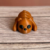 3D printed brown bear-shaped keychain on a wooden surface
