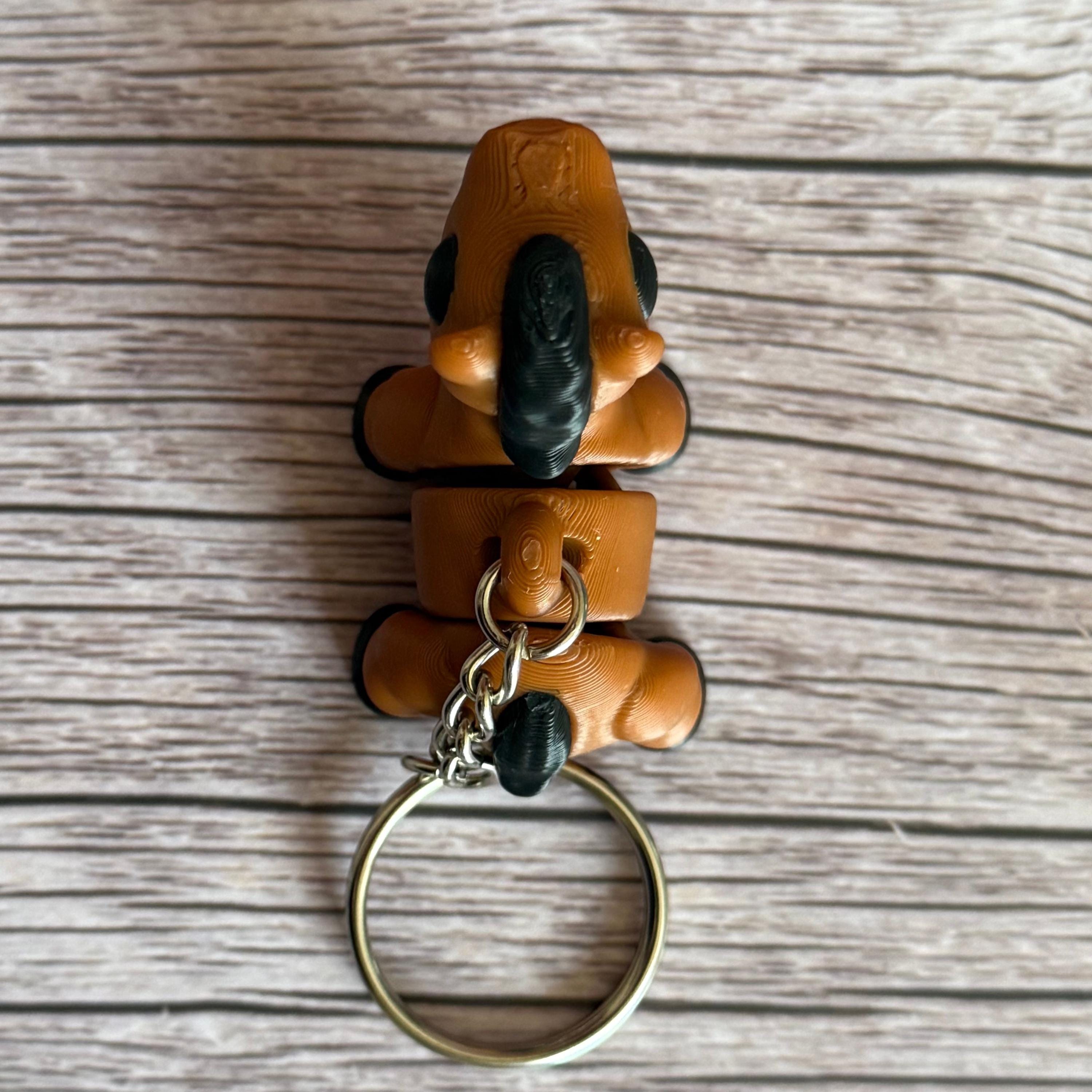 top of a 3D printed brown and black horse-shaped keychain on a wooden surface