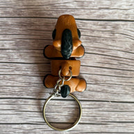 top of a 3D printed brown and black horse-shaped keychain on a wooden surface