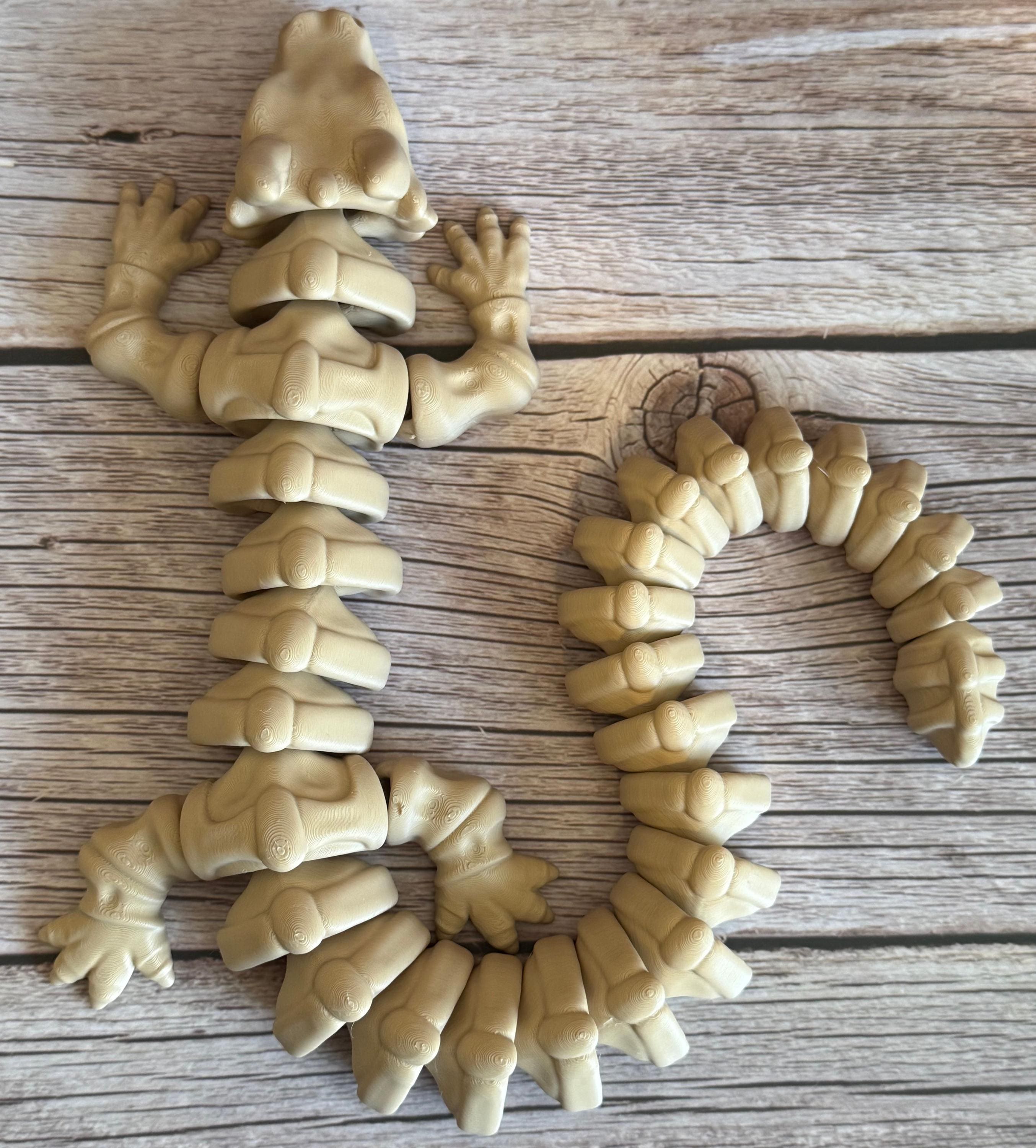 top of a 3D printed beige dragon skeleton toy, placed on a wooden surface