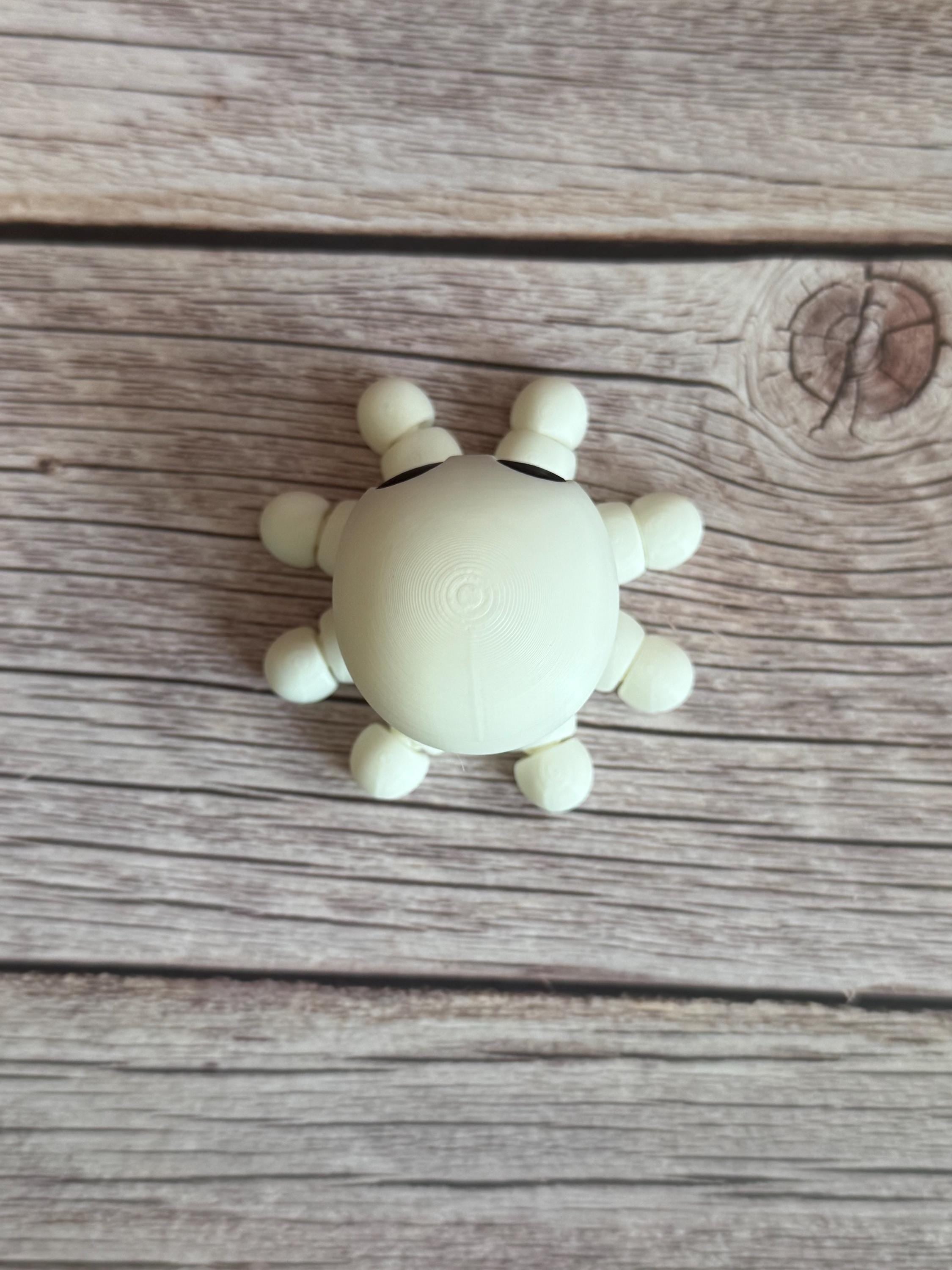 White 3D printed skeleton-like octopus placed on a wooden surface