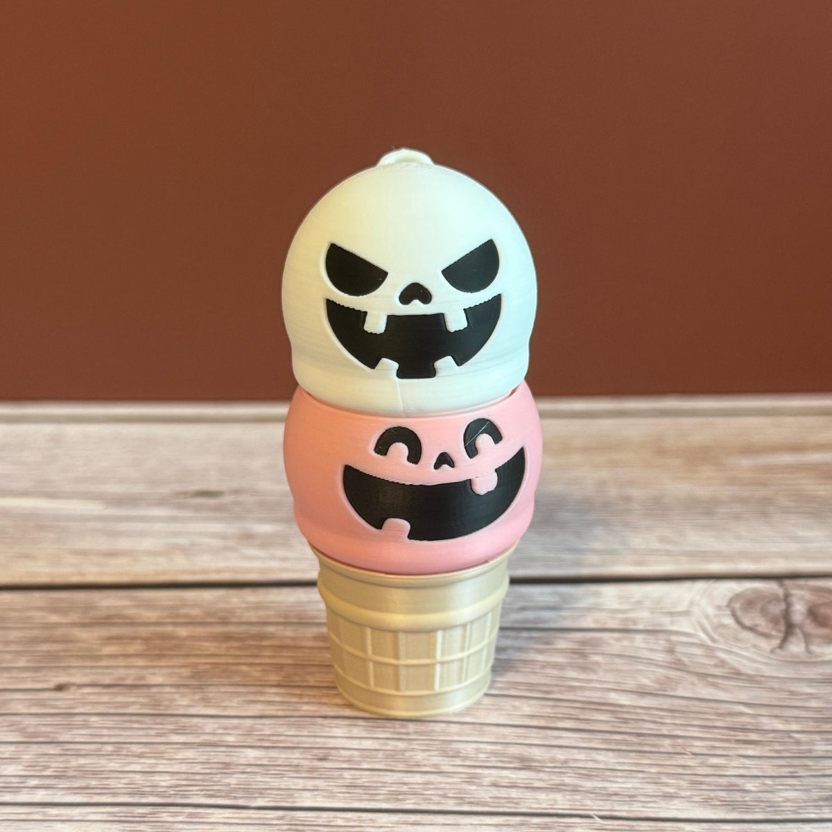 Pink and White 3D printed ice cream cone keychain with smiling and mischievous expressions on the ice cream scoops.
