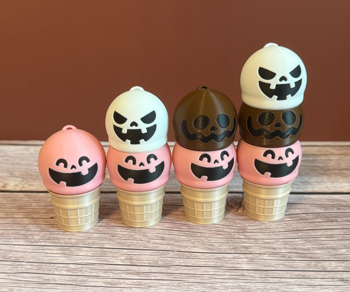 A collection of 3D printed ice cream cone keychains with various colorful designs, featuring expressions like smiling, goofy, and mischievous faces on the ice cream scoops.