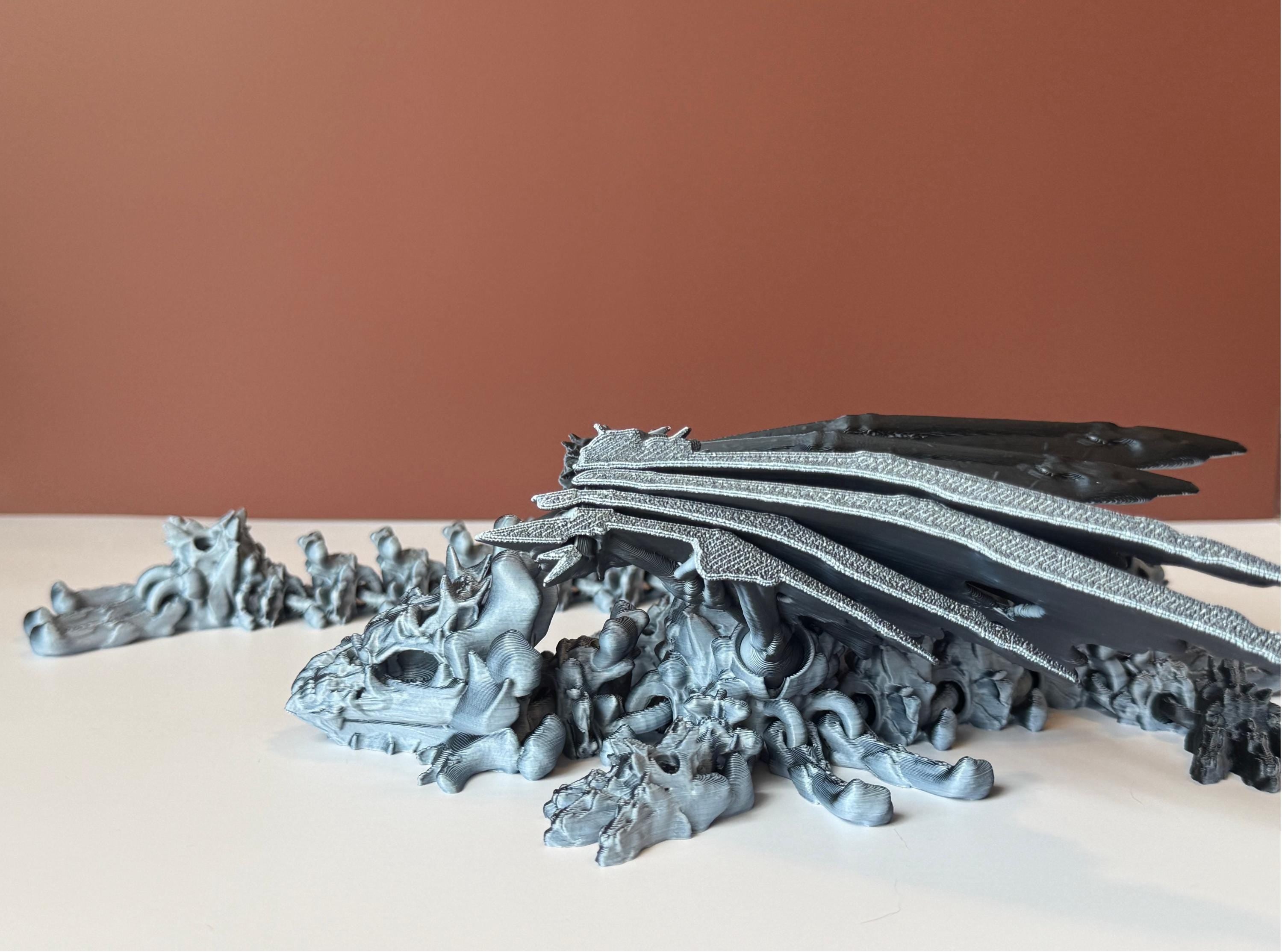 Winged black and white 3d printed dragon with a hollow theme consisting of skulls and bone-like features against a white and brown background