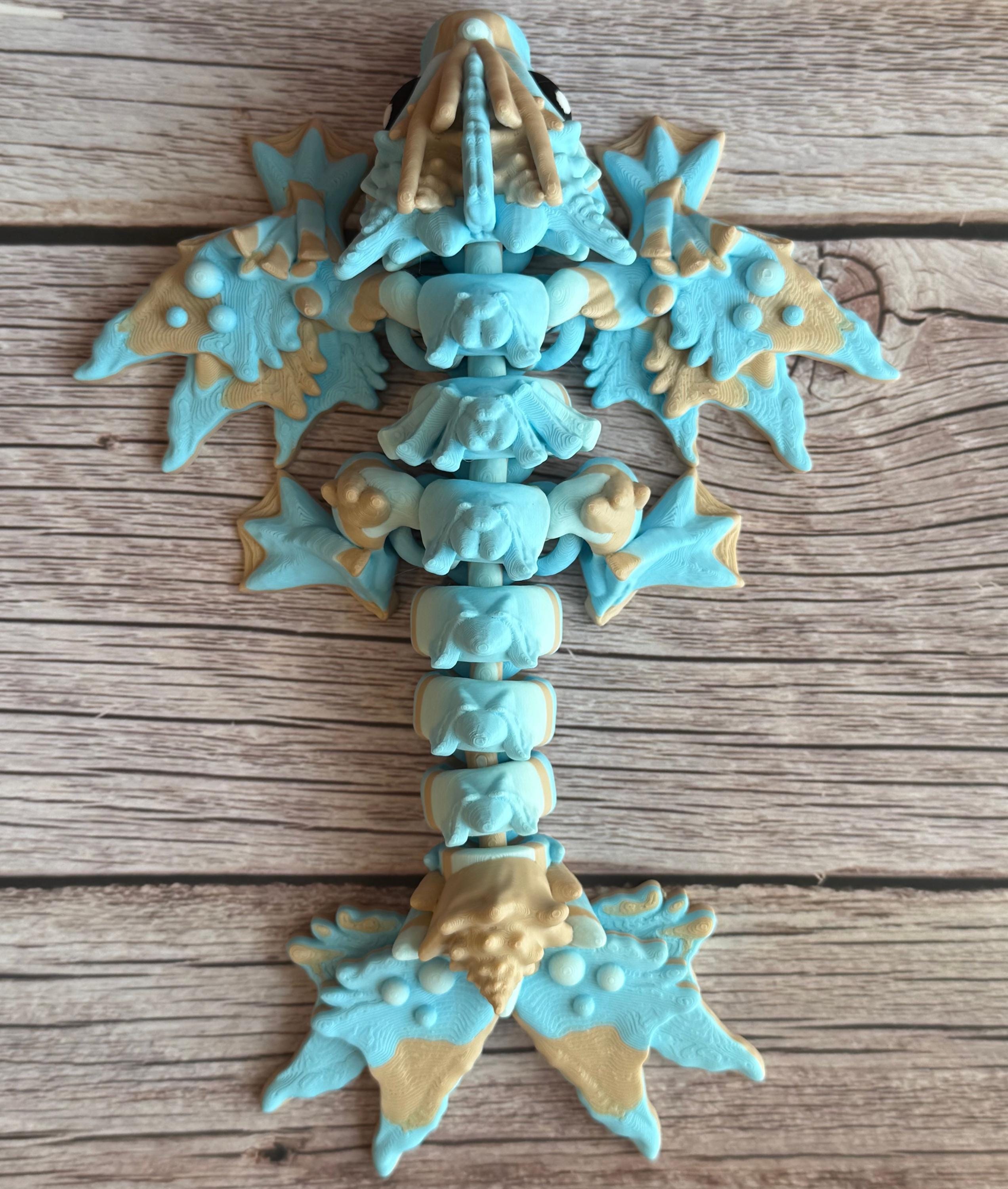 Toy dragon ocean themed figurine with blue and beige colors sitting on a wooden surface