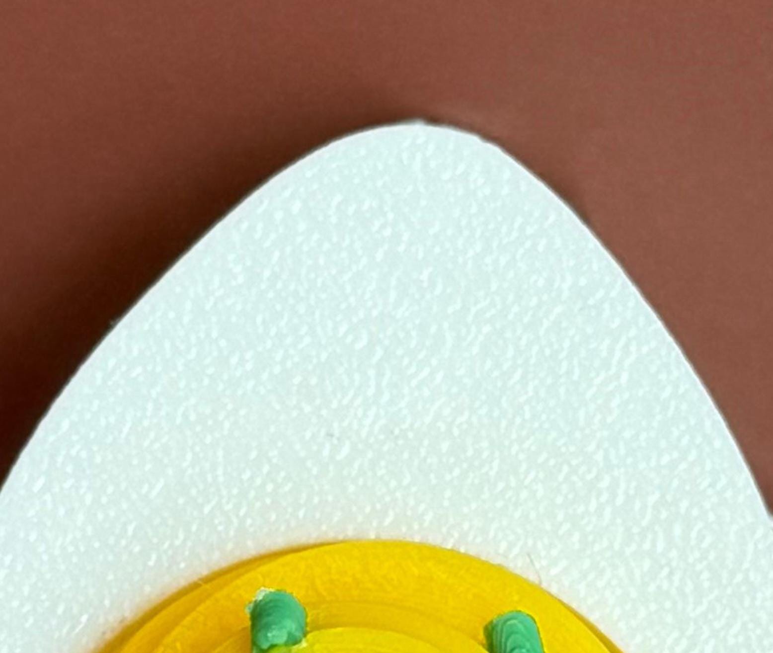 hard-boiled egg keychain with no cartoonish design on a brown background