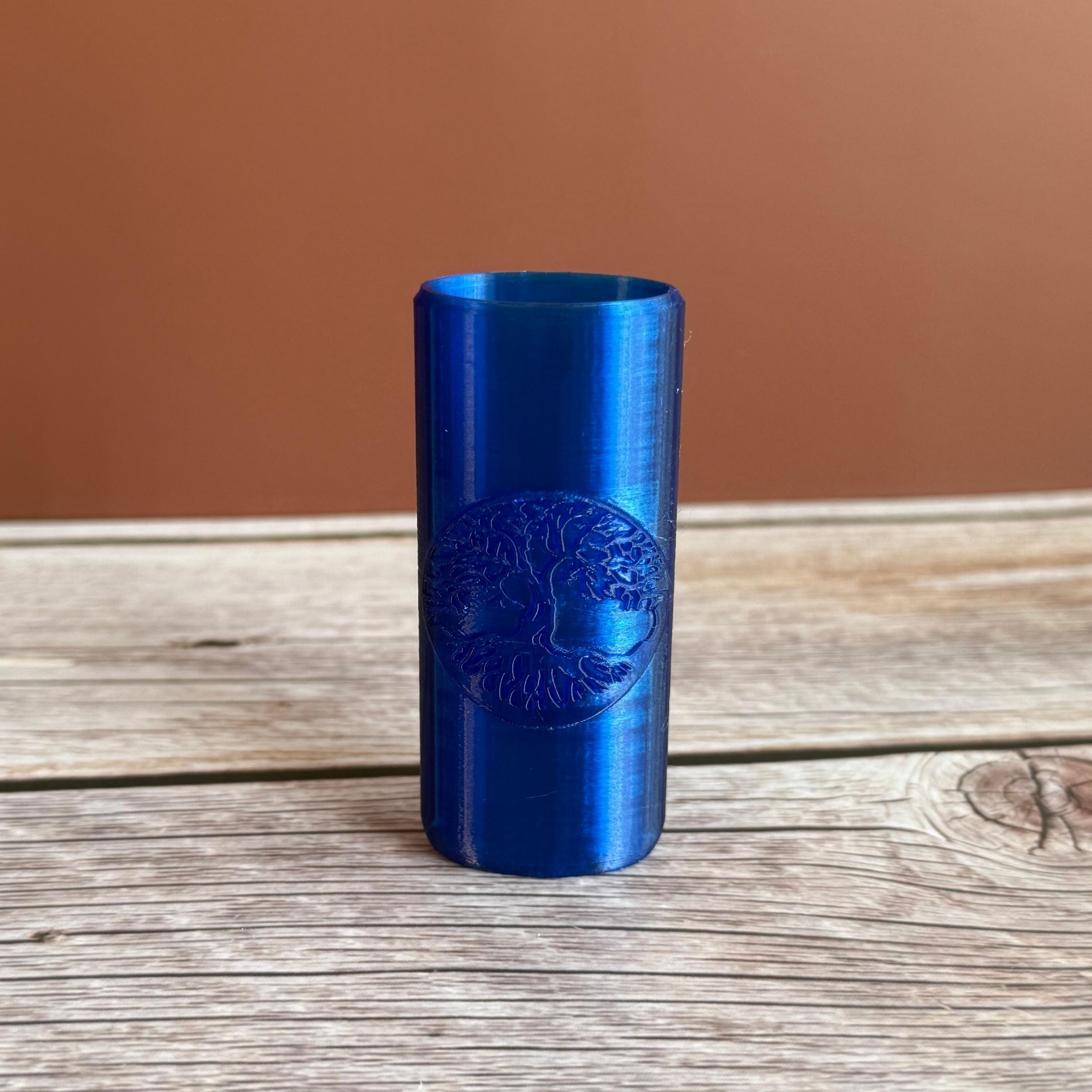 A 3D printed Bic lighter case with Tree of Life design displayed in blue color on wooden surface and brown background