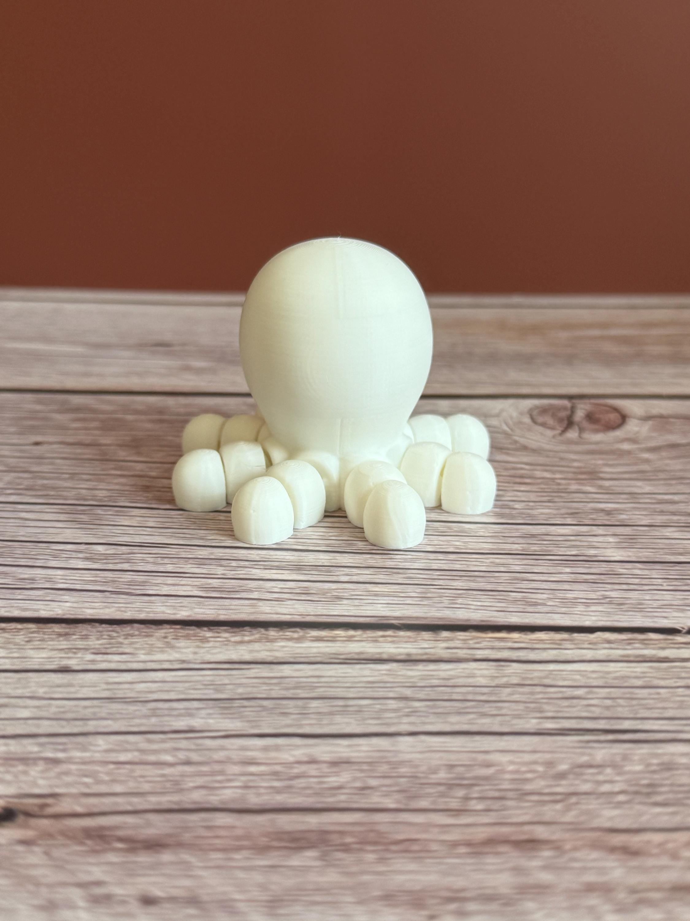 White 3D printed skeleton-like octopus placed on a wooden surface