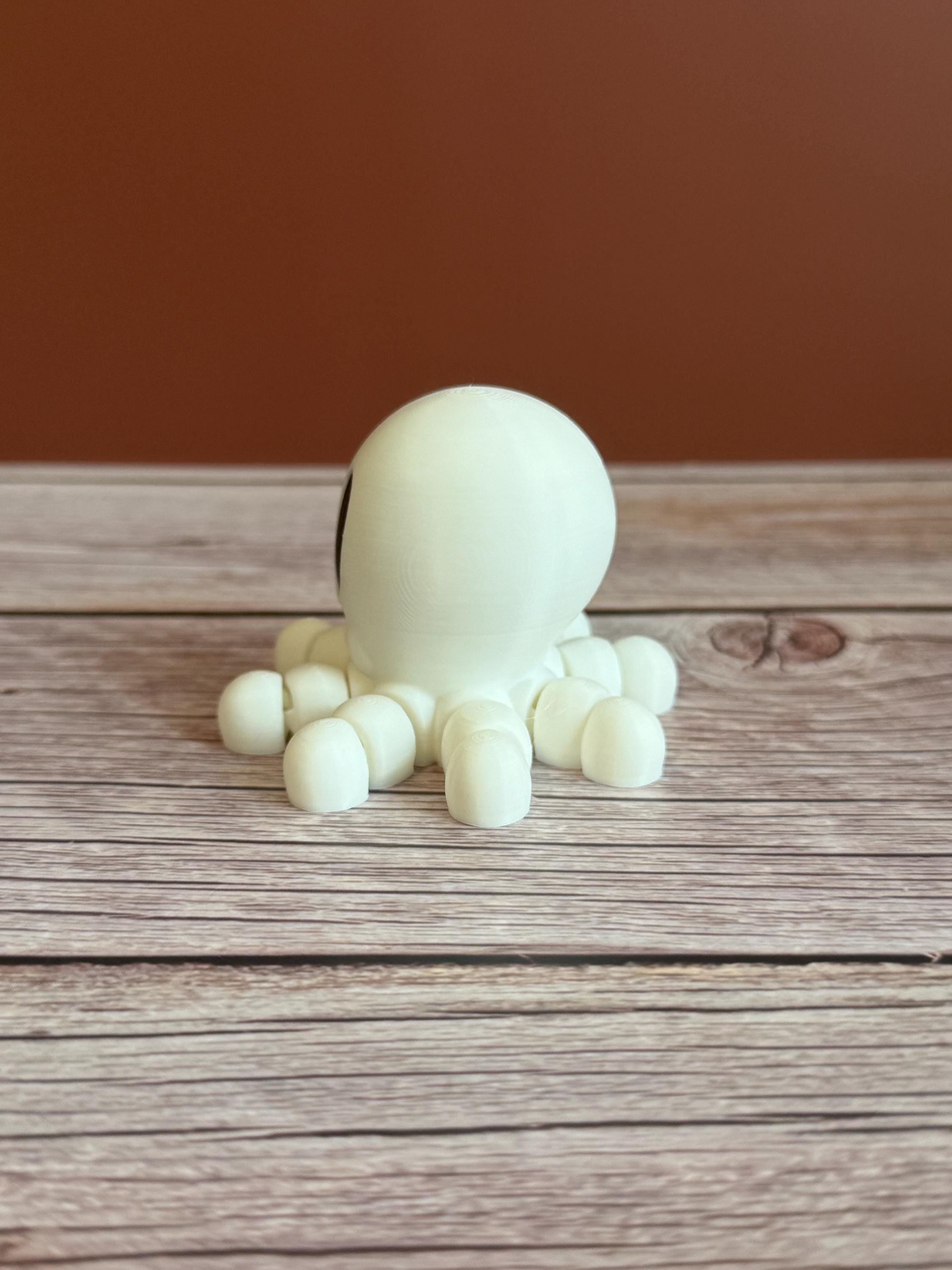 White 3D printed skeleton-like octopus placed on a wooden surface