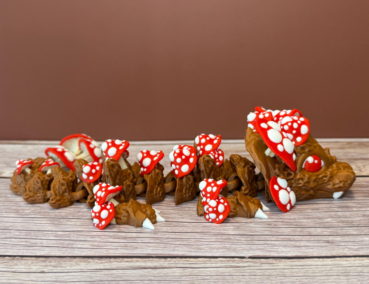 A 12-inch articulated 3D printed dragon with a design resembling a mushroom, with red and white caps on a wooden surface.