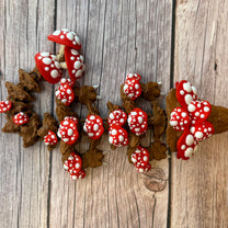 A 12-inch articulated 3D printed dragon with a design resembling a mushroom, with red and white caps on a wooden surface.