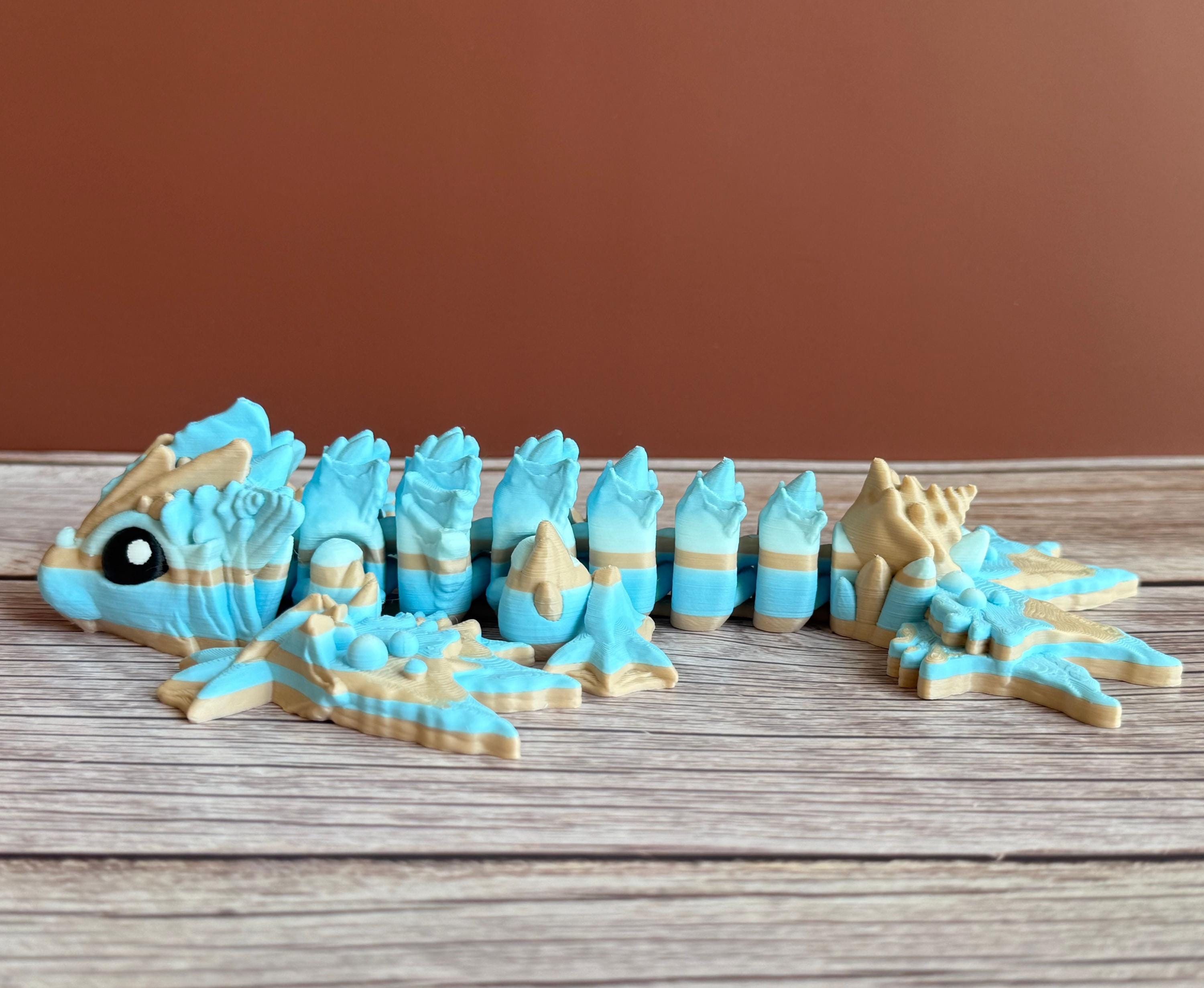Toy dragon ocean themed figurine with blue and beige colors sitting on a wooden surface