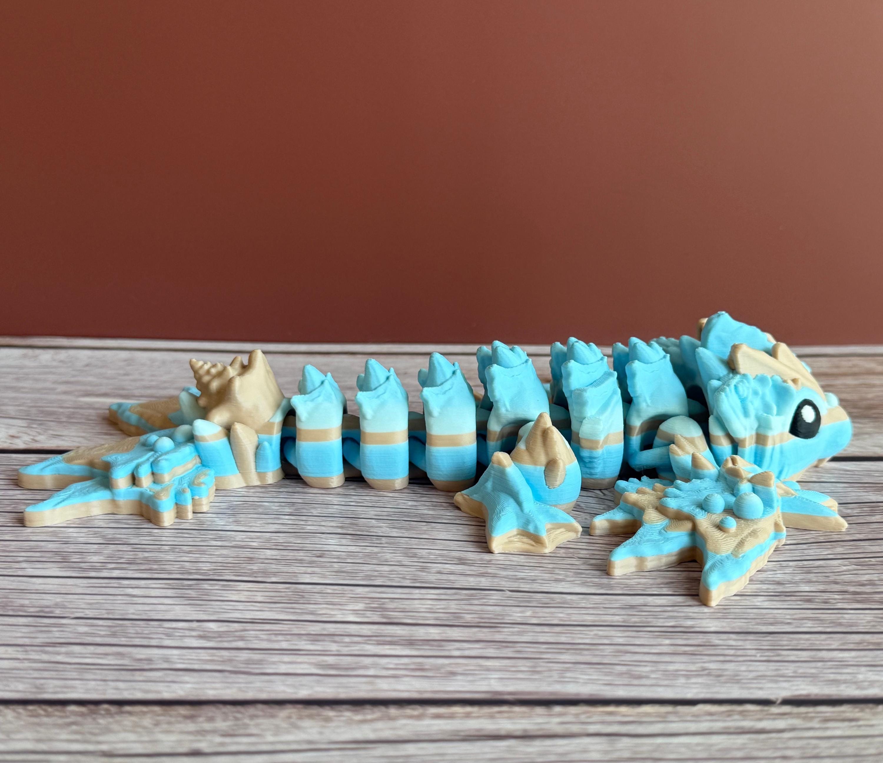 Toy dragon ocean themed figurine with blue and beige colors sitting on a wooden surface