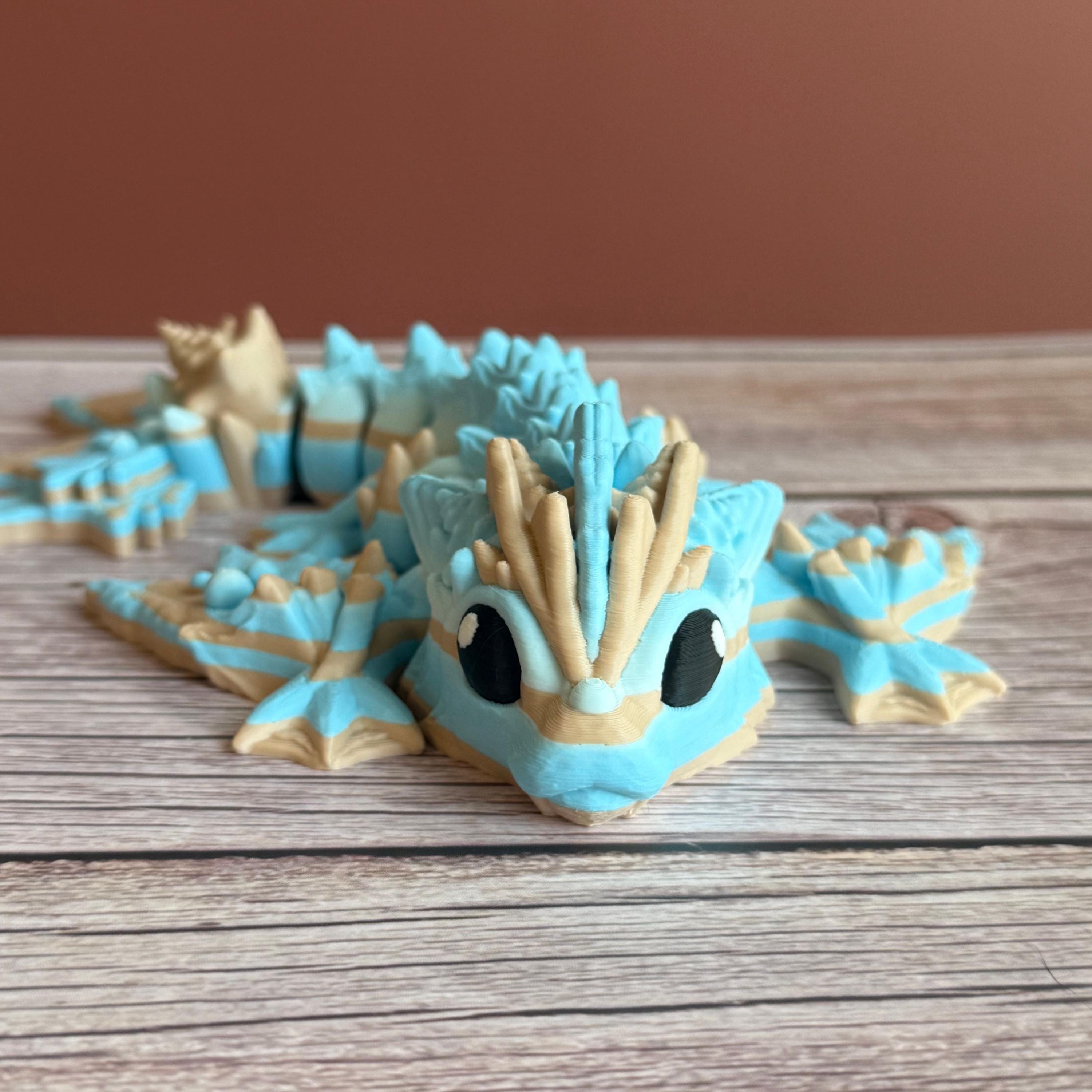 Toy dragon ocean themed figurine with blue and beige colors sitting on a wooden surface
